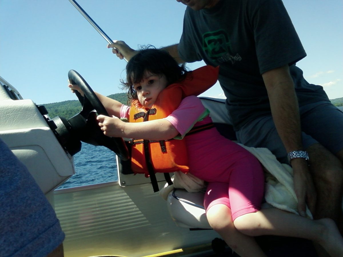 Avi at the boat wheel on Lake George