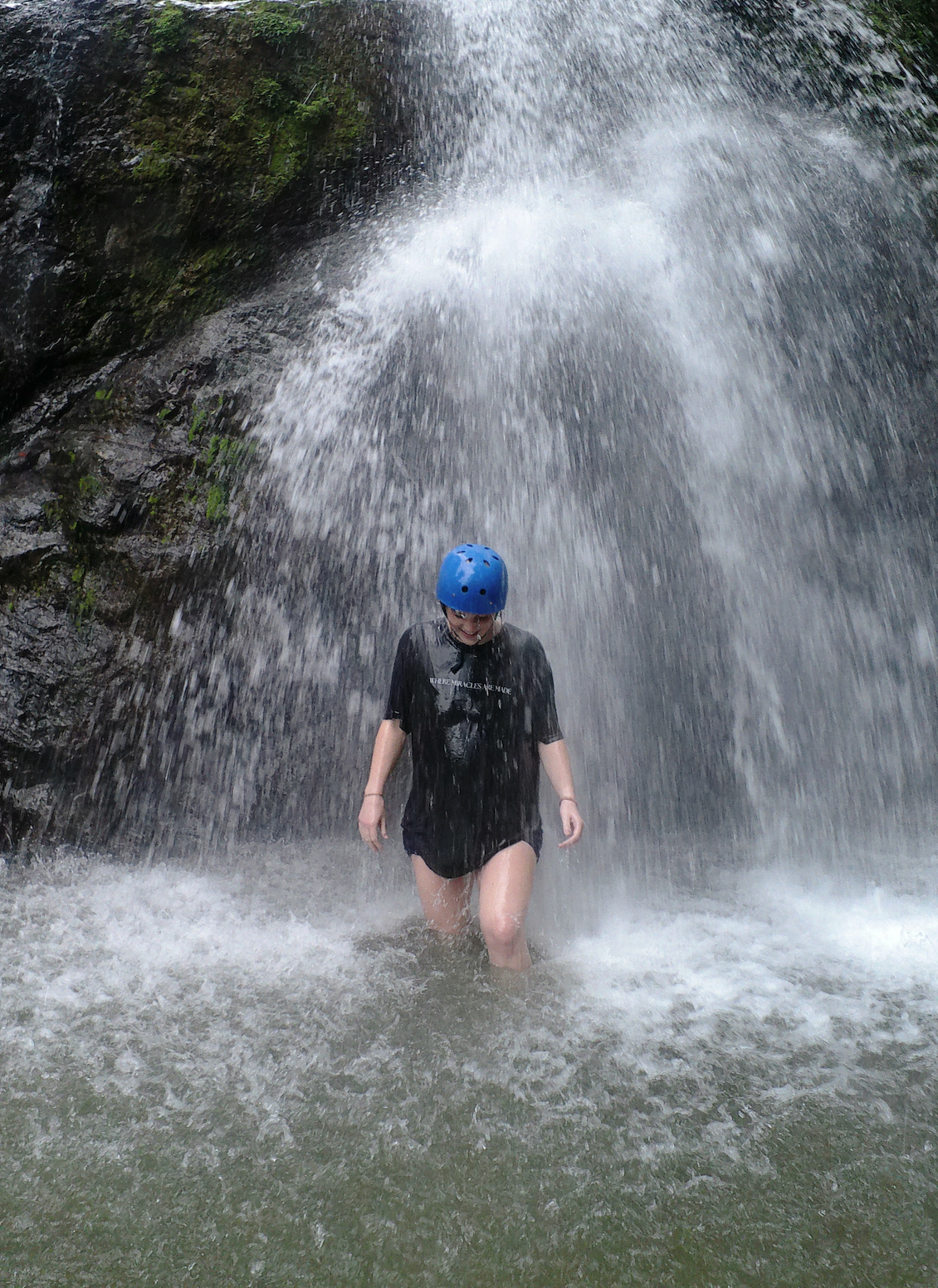 Avi standing under a waterfall in a helmet